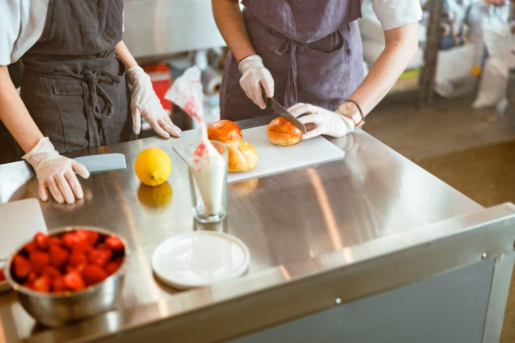 Food safety in catering session. showing a budding chef how to correctly slice vegetables.